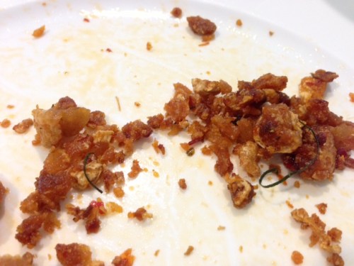 The remnants of a "gra moo" (pork crackling stir-fried with herbs)