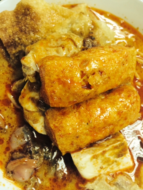 Chinese-style laksa with tofu, fried wontons, egg noodles and cockles