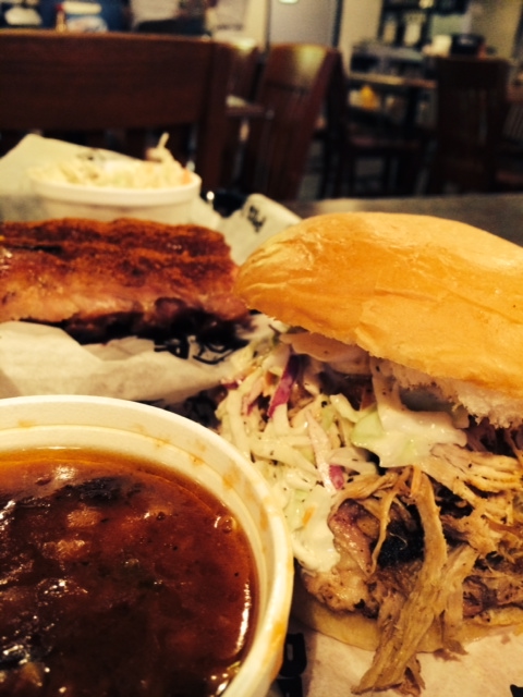 Baked beans and pulled pork sandwich, with dry-rubbed ribs in the background
